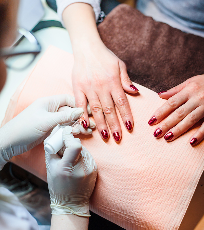 Beautician in a beauty salon doing a hybrid manicure